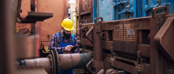 railroad-worker-checking-cargo-containers-freight-train-station-700x350